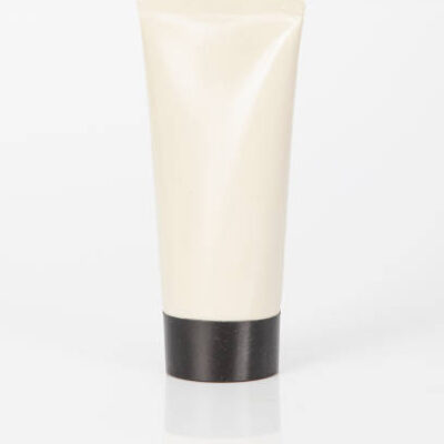 Skin cream container with black lid; photo on white background.
